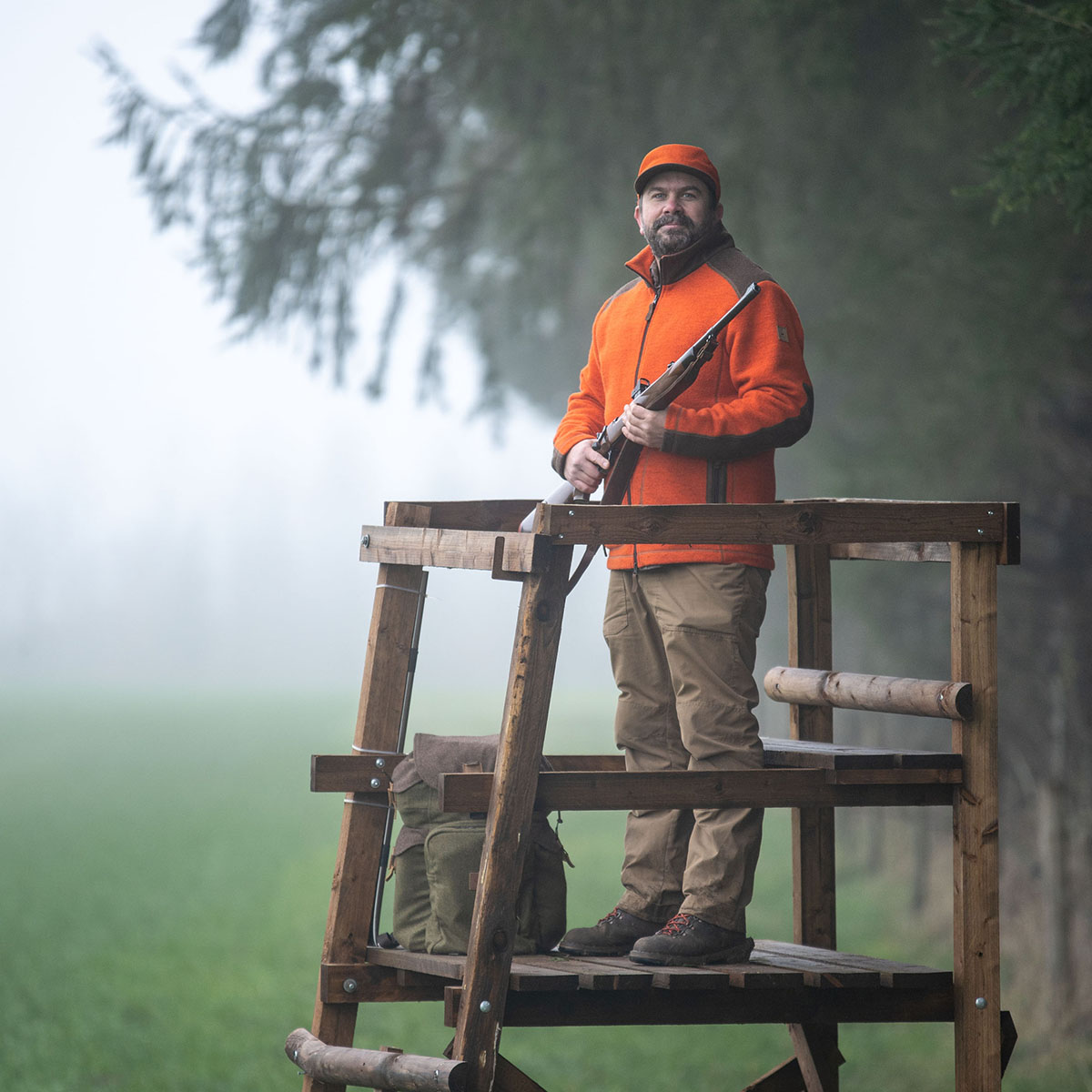 Jäger schaut von Hochstand im Nebel