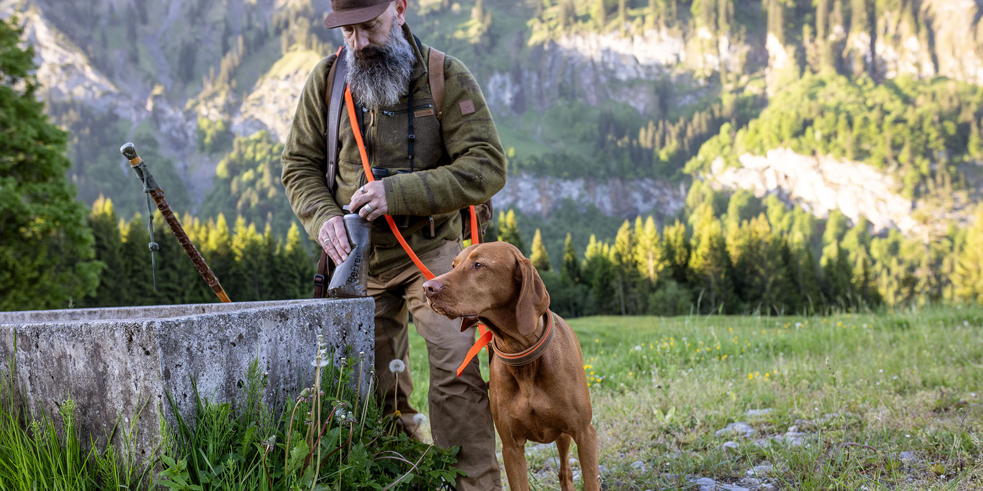 Jäger mit Hund an Steinbecken