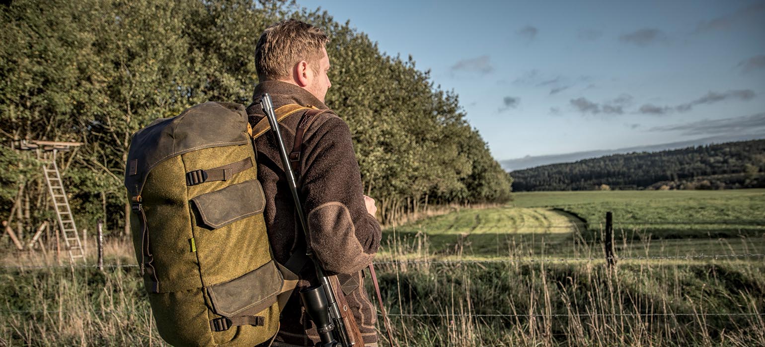 Jäger mit Jagdrucksack an Feld